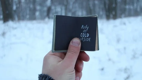 Winter concept. Baby it's cold outside. Vintage book with inscription Stock Footage