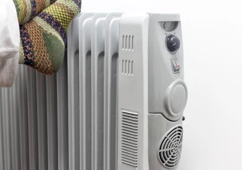 Winter concept. Unknown sick man placed his feets on a heater getting warm. Stock Photos