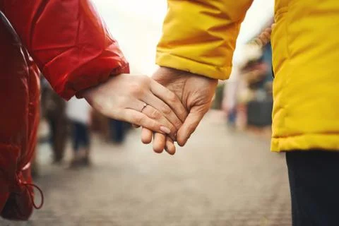 Winter couple holding hands while walking city street. Stock Photos