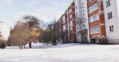 Winter courtyard surrounded by five-story. A boy on a leash is walking his dog. Stock Footage 238774829
