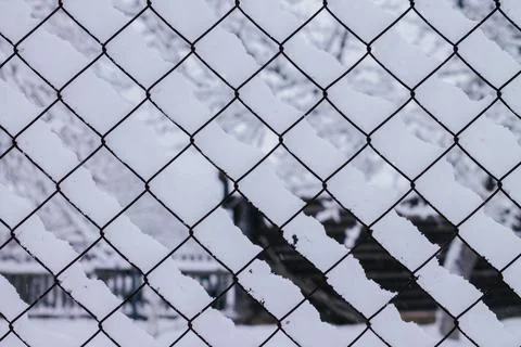 Winter creative background image. Snow, lying on mesh cells of chain-link Stock Photos