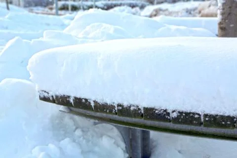 Winter day, bench covered with a thick layer of snow Stock Photos