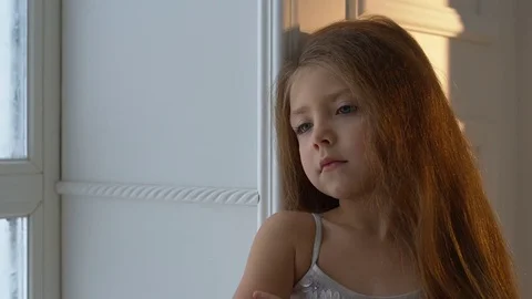 Winter Day. Girl looking out the window at the falling snow Stock Footage 70777053