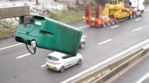 Winter day view average speed traffic camera under falling snow over UK Motorway Photos