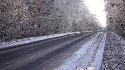 Winter day view with empty road and snow-covered forest. Video stock 99439276