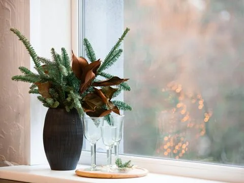 Winter decor composition - spruce branches and dried leaves in a brown vase o Stock Photos