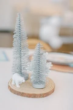 Winter decor featuring small white trees and a bear figurine on a rustic wooden Stock-Fotos
