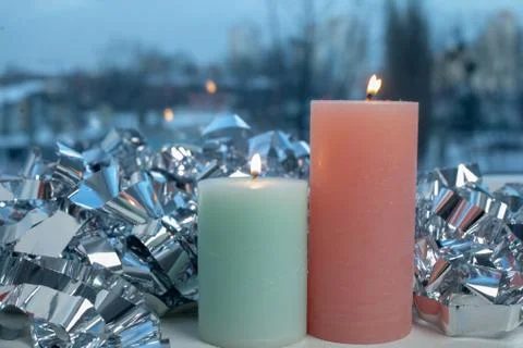 Winter decor on windowsill with two candle and silver foil Stock-Fotos