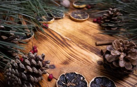 Winter decorations Pine cones cinnamon dried orange on a wood background Stock Photos