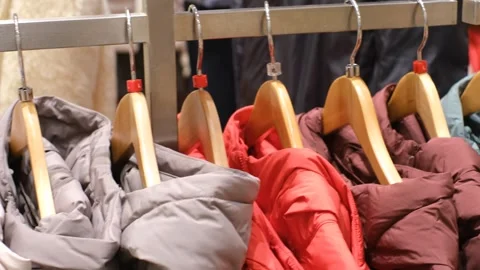 Winter down jackets hanging on hangers in the store close-up, side view. Stock Footage 322219707