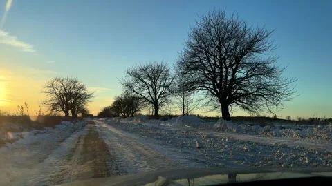 Winter drive on snowy road under clear sky at sunset 스톡 동영상 331901602