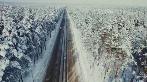 Winter drive through snow-covered forest roads in a serene landscape Stock Footage 291375406