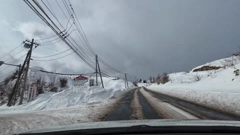Winter driving on open snowy road with power lines Hokkaido Japan Vídeo Stock 333205048