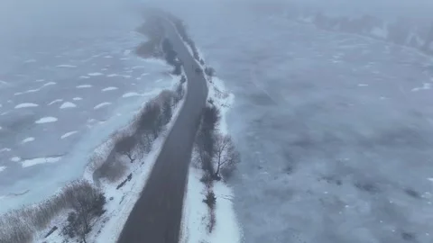 Winter Drone Flight Along Road Between Frozen Quarry Lakes in Dense Fog Stock Footage 340328726