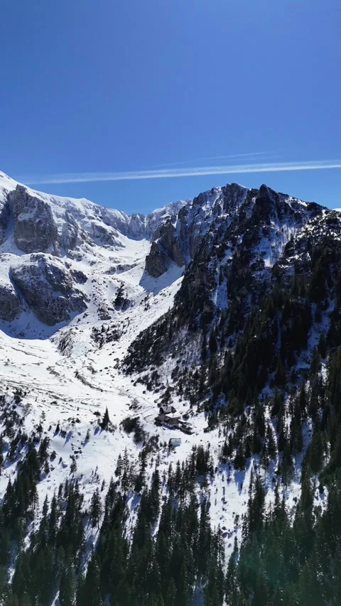Winter Drone Footage of Bucegi Mountain Peaks and Alpine Chalet Stock Footage 333979880