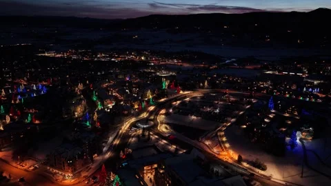 Winter drone view over a festive mountain town reveals snow covered buildings 스톡 동영상 347569295