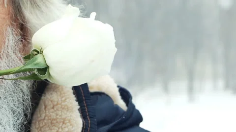 Winter. an elderly man with a beard holding a flower in his teeth Stock Footage 85894622
