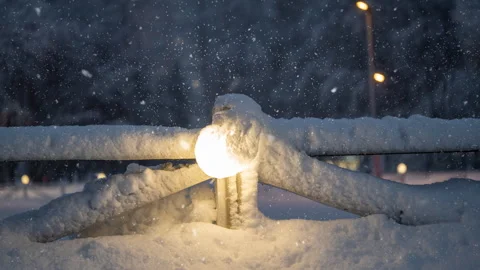 Winter Evening Cinemagraph: Snow-Covered Streetlamp in Urban Loop Stock Footage 306584055