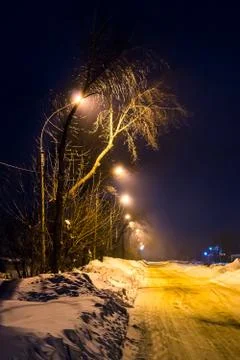Winter evening illuminated by lanterns empty street Stock Photos