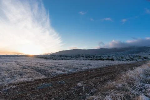 Winter fields sunset with clouds moving by wind Stock Photos