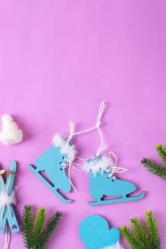 Winter flat lay with small ice skates, mitten and knitted hat on pink Foto stock