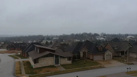 Winter Fly over of homes with snow falling from aerial drone shot 库存影片 124412619