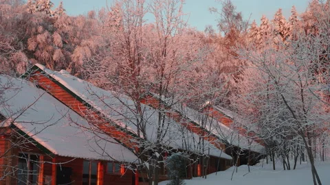 Winter forest and small wooden houses in the red sunrise Stock Footage 123715981
