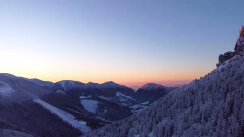 Winter forest on the edge of a rocky mountain at dusk. View from a drone, sunset Stock-Footage 227713500