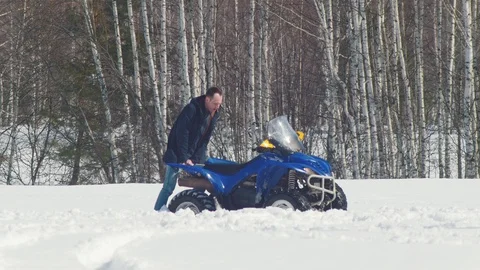 A winter forest. A man getting the snowmobile out of the snowdrift Stock Footage 106885817