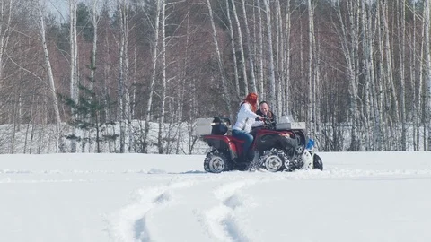 A winter forest. A man having a problem with snowmobile and woman riding around Stock Footage 106889922