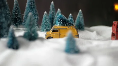 Winter forest miniature with a small yellow toy car with a Christmas tree on the Stock Footage 116544899