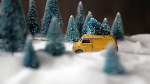 Winter forest miniature with a small yellow toy car with a Christmas tree on the Stock Footage 116603601