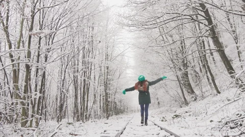 The winter forest opens up in front of this young woman as she moves forward Stock Footage 257622256