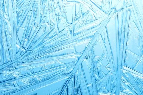 Winter frost covered window with a pattern of ice crystals. Stock Photos