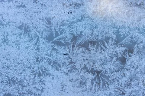 Winter frost patterns creating natural ice texture on glass Stock Photos