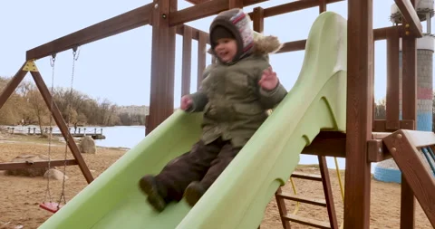 Winter Fun at the Slide: Child Sliding Down with Mom's Help Stock Footage 238763560