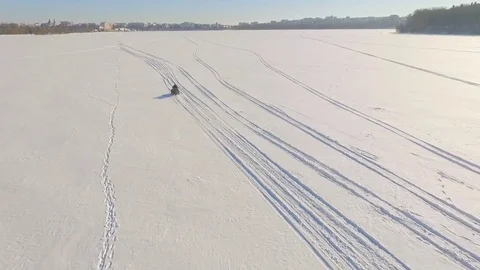 Winter fun. A trip on a snowmobile. Two guys are riding a snowmobile over frozen Stock Footage 84329009