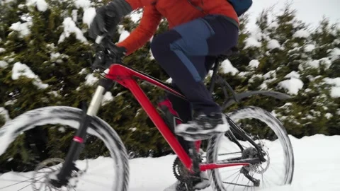 In winter, a guy rides a bicycle through deep snow among snow covered trees Stock Footage 263576957