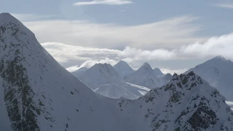 Winter high altitude mountains with clouds moving in sky during day time Stock Footage 121575912