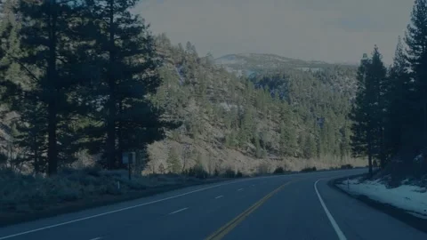 Winter highway curving through pine forest with snowy Sierra Nevada... Stockbeeldmateriaal 328254664