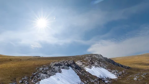 Winter hill with dry grass and snow under a sparkle sun Vídeo Stock 333670043