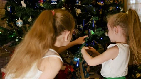 Winter holidays concept. Two little girls decorate the Christmas tree. Boxing Stock Footage 145186548