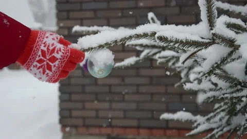 Winter holidays, snow on the Christmas tree with a balloon. Stock Footage 177456745