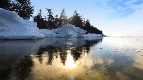 Winter ice and snow piles along shoreline. Stock Footage 124875574
