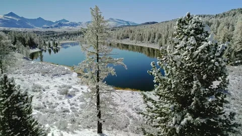 Winter landscape aerial view over frozen mountain lake surrounded by snow Stock Footage 343696662
