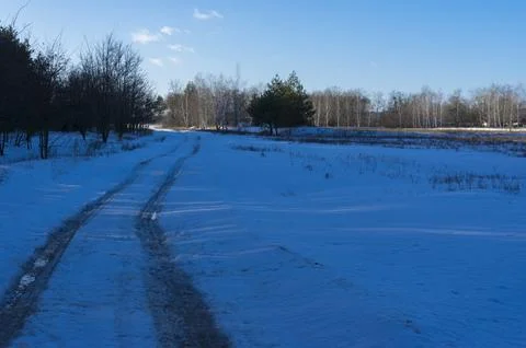 Winter landscape with back with root to small village Derevky Stock Photos