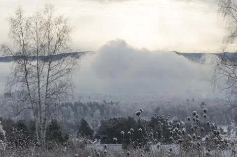 Winter landscape big cloud over the river against the mountains Stock Photos