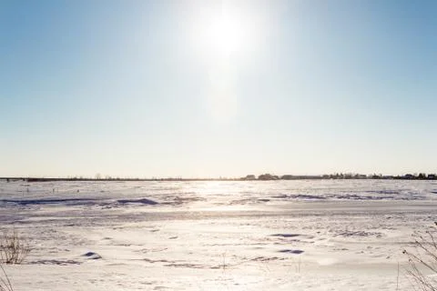 Winter landscape with blue sky in the spring sun and village in the backgroun Stock Photos