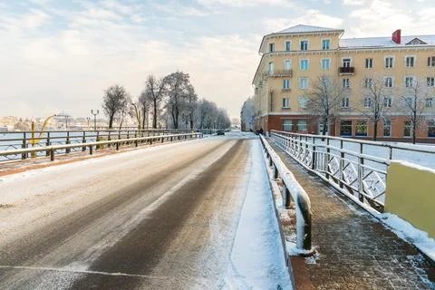 Winter landscape in the city at sunset. An empty road covered with snow and i Stock Photos