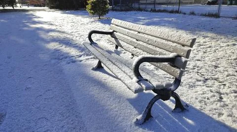 Winter landscape.  Empty park bench with fresh snow. Stock Photos
